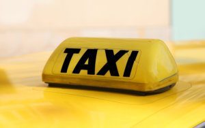 Writting taxi in black on a yellow taxi