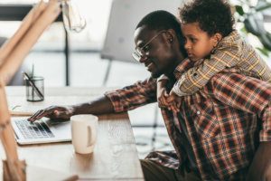 Father and son using laptop in office