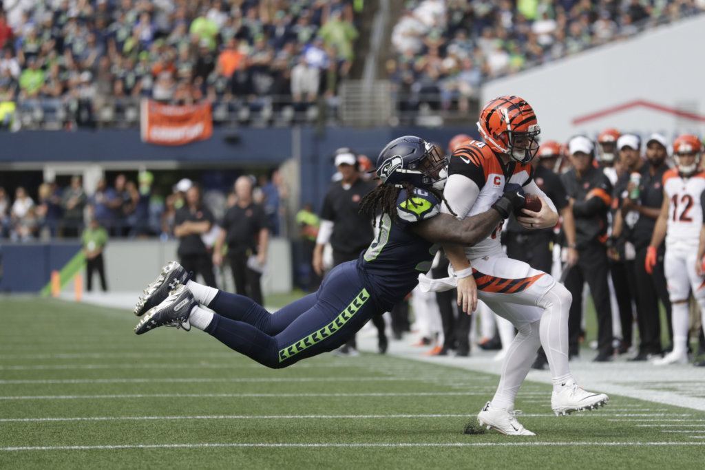 Seattle Seahawks defensive end Jadeveon Clowney, left, tackles Cincinnati Bengals quarterback Andy Dalton, right, during the second half of an NFL football game, Sunday, Sept. 8, 2019, in Seattle.