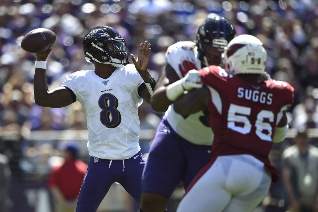 Baltimore Ravens quarterback Lamar Jackson (8) throws to a receiver as he is pressured by Arizona Cardinals outside linebacker Terrell Suggs (56) in the first half of an NFL football game, Sunday, Sept. 15, 2019, in Baltimore.