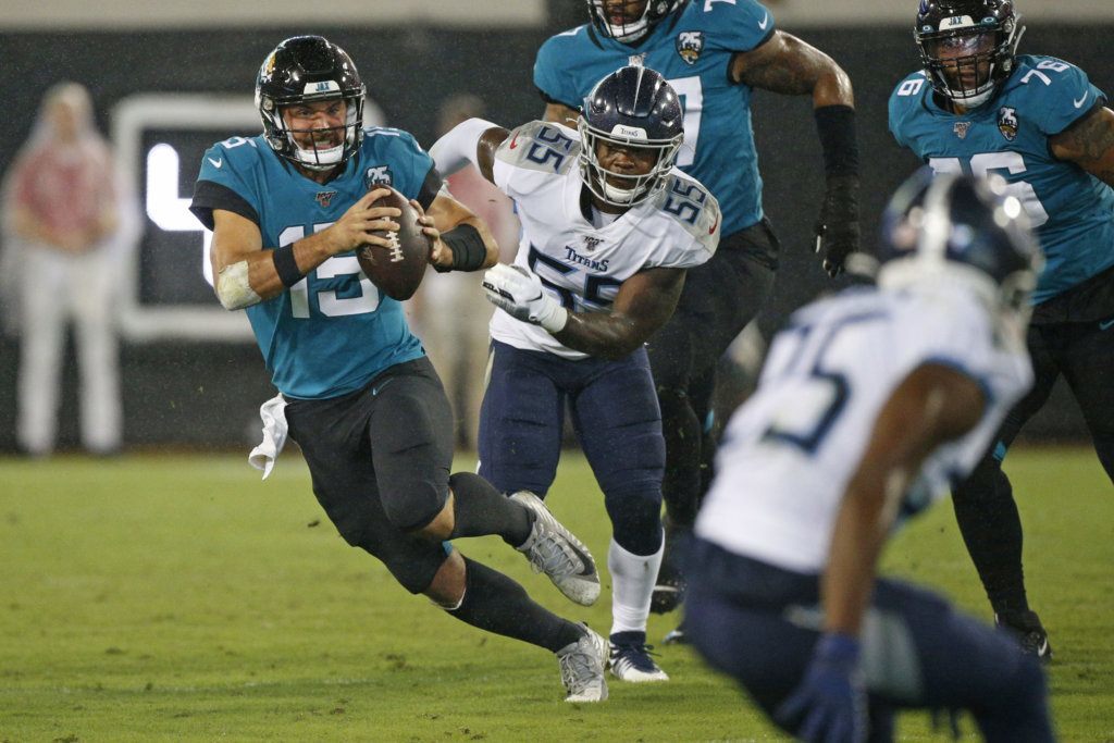 Jacksonville Jaguars quarterback Gardner Minshew, left, scrambles away from Tennessee Titans inside linebacker Jayon Brown (55) during the first half of an NFL football game, Thursday, Sept. 19, 2019, in Jacksonville, Fla.