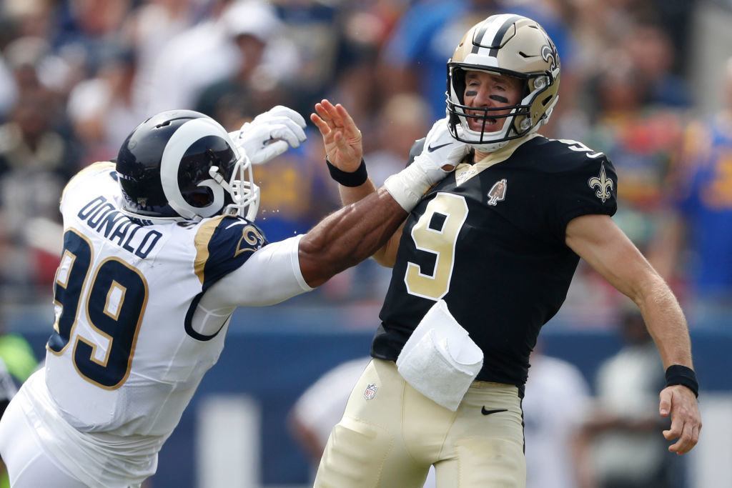 LOS ANGELES, CALIFORNIA — SEPTEMBER 15: Drew Brees #9 of the New Orleans Saints injures his throwing hand as he is hit by Aaron Donald #99 of the Los Angeles Rams during the first quarter in the gameat Los Angeles Memorial Coliseum on September 15, 2019 in Los Angeles, California.