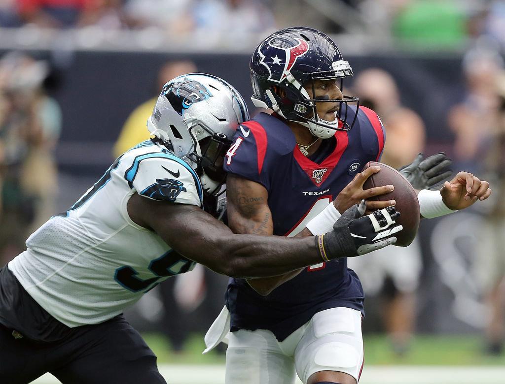 HOUSTON, TEXAS — SEPTEMBER 29: Deshaun Watson #4 of the Houston Texans is sacked by Mario Addison #97 of the Carolina Panthers during the first half at NRG Stadium on September 29, 2019 in Houston, Texas.