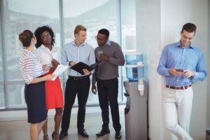 Business colleagues discussing by water cooler