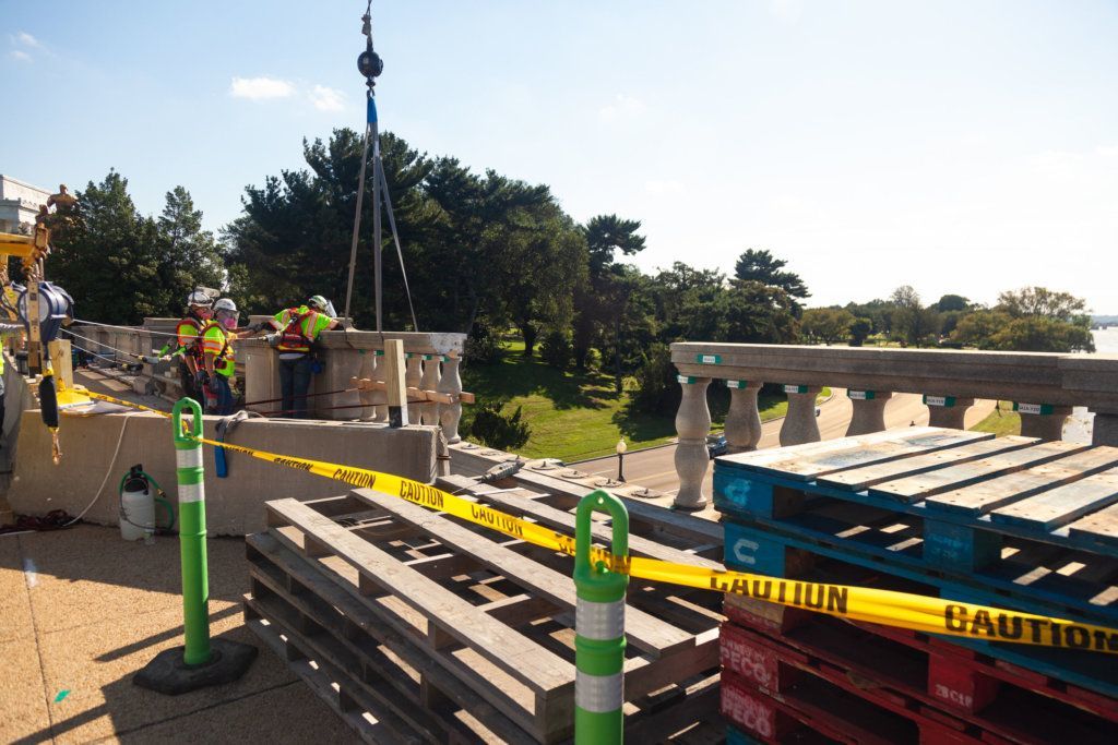 Construction workers remove and package the balustrade of the Arlington Memorial Bridge.