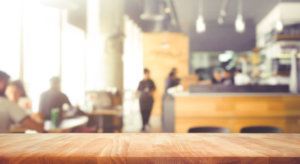 Wood table top with blur of people in coffee shop or (cafe,restaurant )background