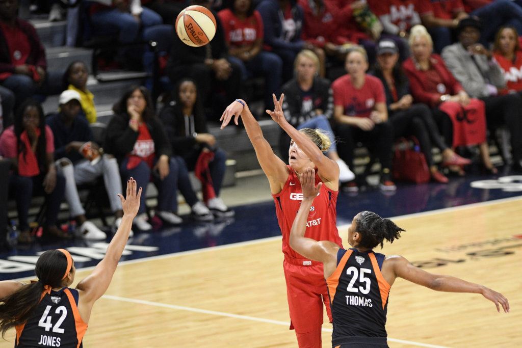 Washington Mystics forward Elena Delle Donne, center, shoots in front of Connecticut Sun center Brionna Jones (42) and forward Alyssa Thomas (25) in the first half of Game 5 of basketball's WNBA Finals, Thursday, Oct. 10, 2019, in Washington.