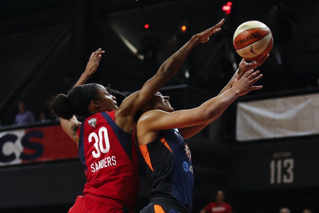 Connecticut Sun forward Alyssa Thomas, right, shoots past Washington Mystics forward LaToya Sanders during the first half of Game 5 of basketball's WNBA Finals, Thursday, Oct. 10, 2019, in Washington.