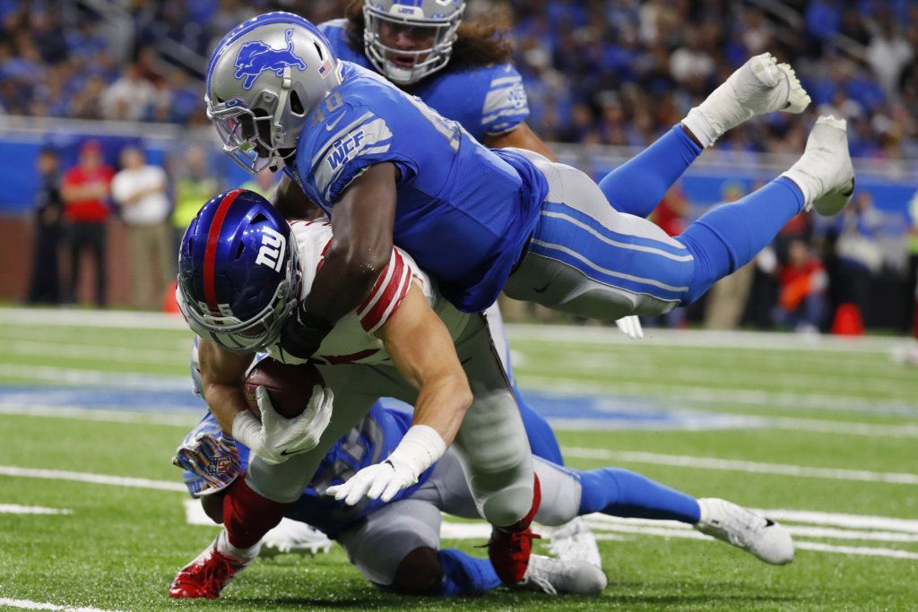 New York Giants tight end Rhett Ellison is tackled by Detroit Lions middle linebacker Jarrad Davis (40) during the second half of an NFL football game, Sunday, Oct. 27, 2019, in Detroit.