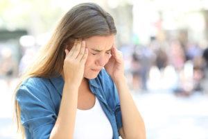 Girl suffering migraine in the street