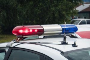 A close up of a swithched rotating beacon of a police car. Cop car rooftop flashing lights outdoors. The top of the police patrol car with flasher and antennas. A patrol car lights. Accident.