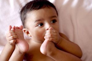 Adorable baby boy sucking his toe