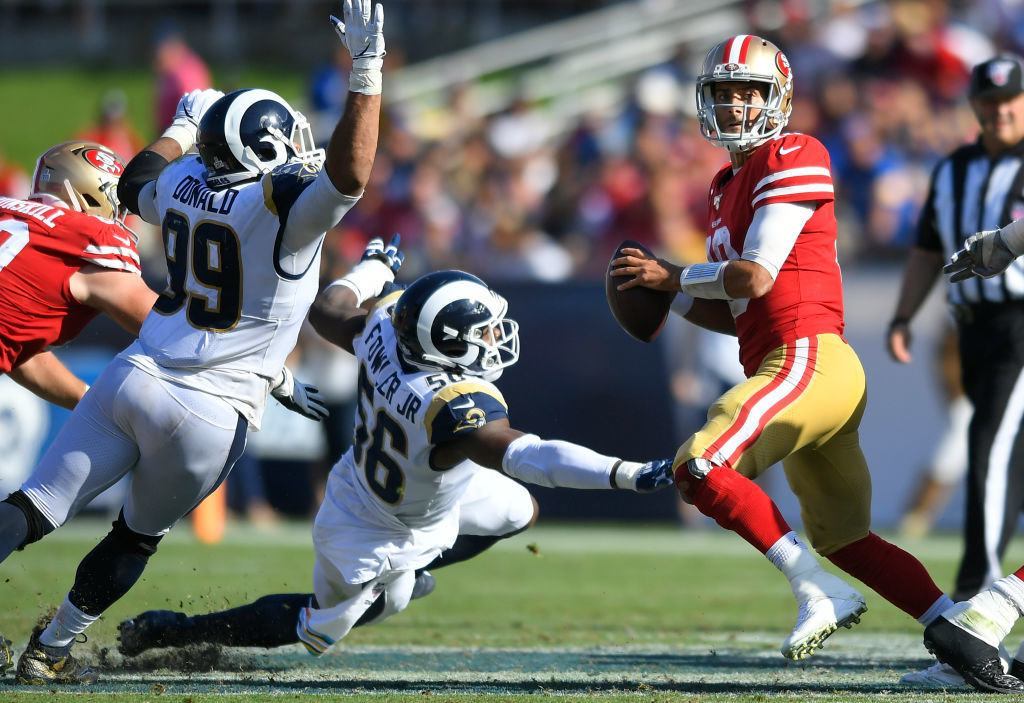 LOS ANGELES, CA - OCTOBER 13: Aaron Donald #99 of the Los Angeles Rams and Dante Fowler #56 put pressure on Jimmy Garoppolo #10 of the San Francisco 49ers who would fumble the ball in the fourth quarter at Los Angeles Memorial Coliseum on October 13, 2019 in Los Angeles, California. San Francisco won 20-7.