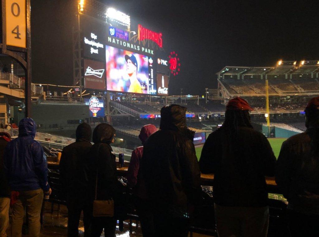 Fans endure rainy weather during a watch party for Game 7 of the World Series.