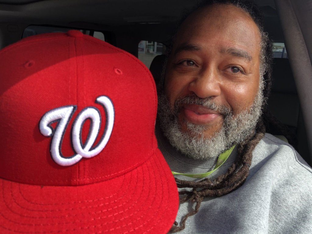 D.C. resident Milton White shows off his latest fitted hat from the Nats' team store. He has one for every year and has come back repeatedly this year to score this one.