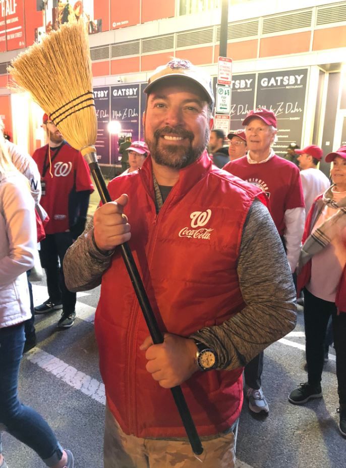 A fan carries a broom to symbolize a sweep for the Nationals during Game 3 of the NLCS.
