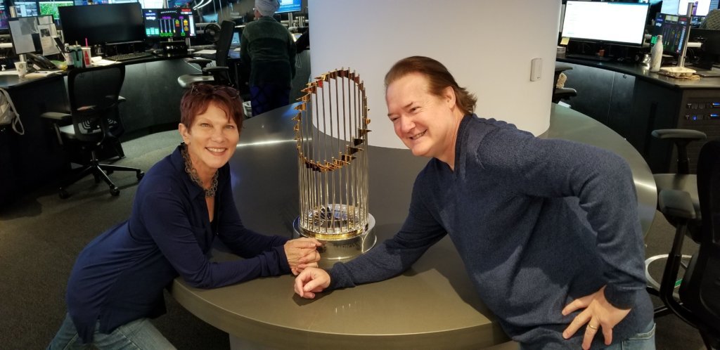 WTOP anchors Hillary Howard, left, and Shawn Anderson pose with the Commissioner's Trophy on Monday, Nov. 18, 2019.
