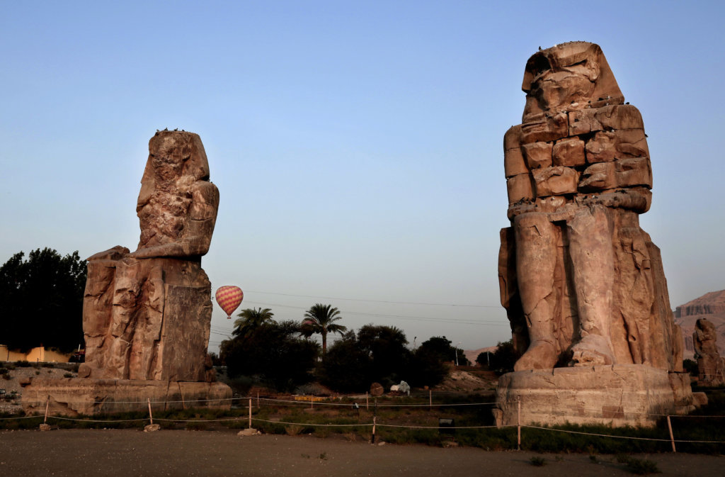 A hot air balloon prepares to land near the Colossi of Memnon, two sandstone statues of Amenhotep III, that stand on the western bank of the Nile River, in Luxor, 320 miles south of Cairo, Egypt, Sunday, Sept. 10, 2017.