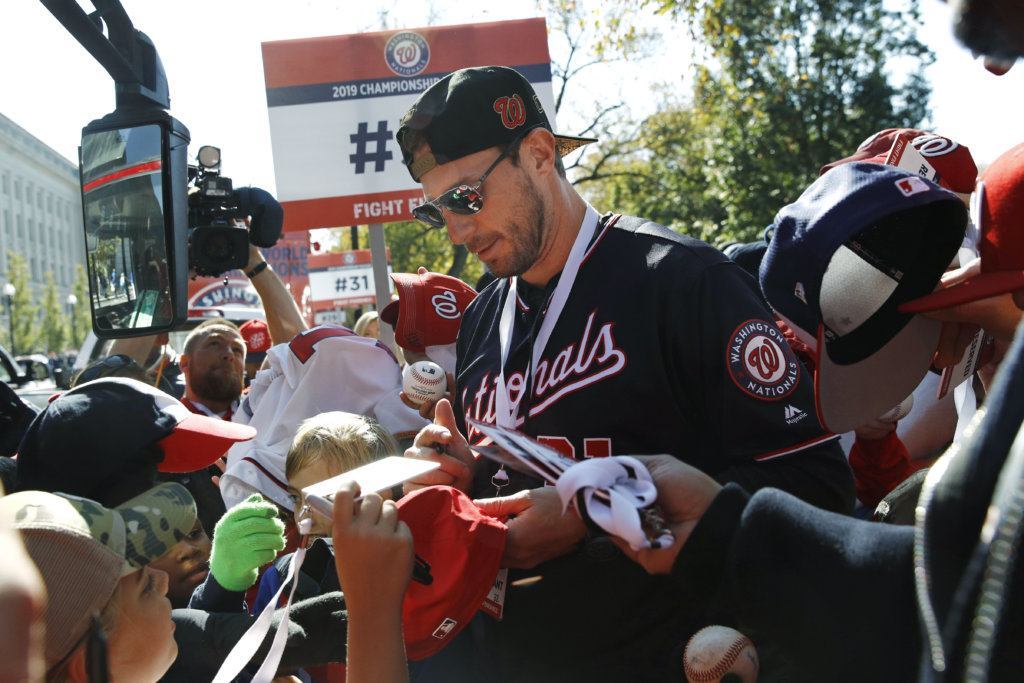 Washington Nationals starting pitcher Max Scherzer signs autographs for fans before a parade to celebrate the team's World Series baseball championship over the Houston Astros, Saturday, Nov. 2, 2019, in Washington.