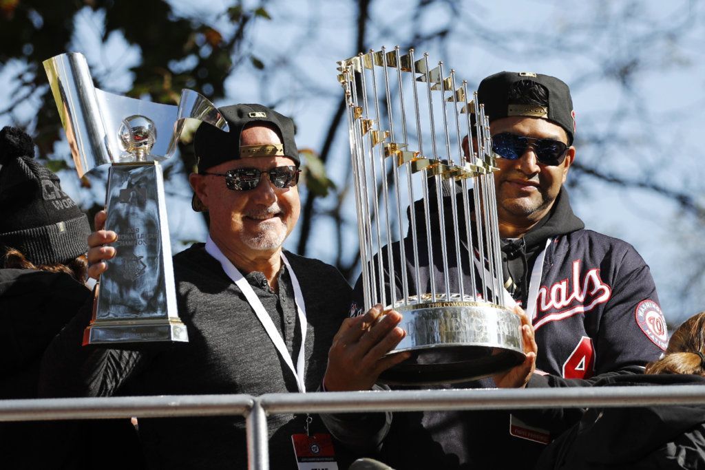 Washington Nationals general manager Mike Rizzo, left, and manager Dave Martinez hold up the NLCS trophy, left, and World Series trophy before a parade to celebrate the team's World Series baseball championship over the Houston Astros, Saturday, Nov. 2, 2019, in Washington. (AP Photo/Patrick Semansky)