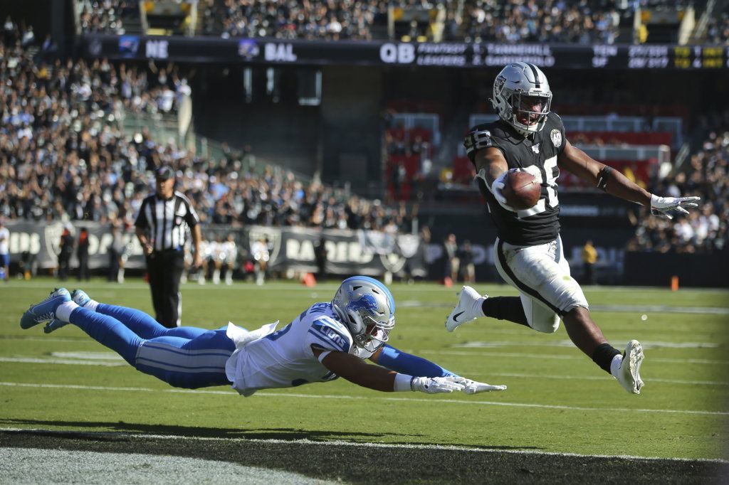 Oakland Raiders running back Josh Jacobs (28) runs for a touchdown past Detroit Lions defensive back Miles Killebrew during the first half of an NFL football game in Oakland, Calif., Sunday, Nov. 3, 2019.