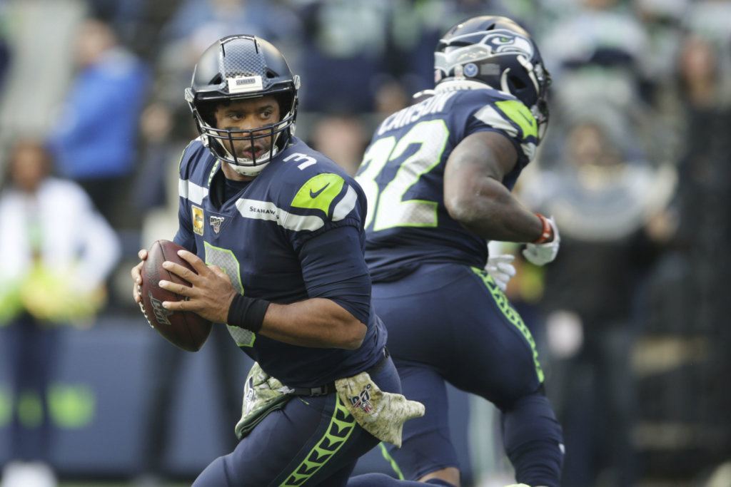 Seattle Seahawks quarterback Russell Wilson drops to make a touchdown pass to Seahawks tight end Jacob Hollister (not shown), during the first half of an NFL football game against the Tampa Bay Buccaneers, Sunday, Nov. 3, 2019, in Seattle.