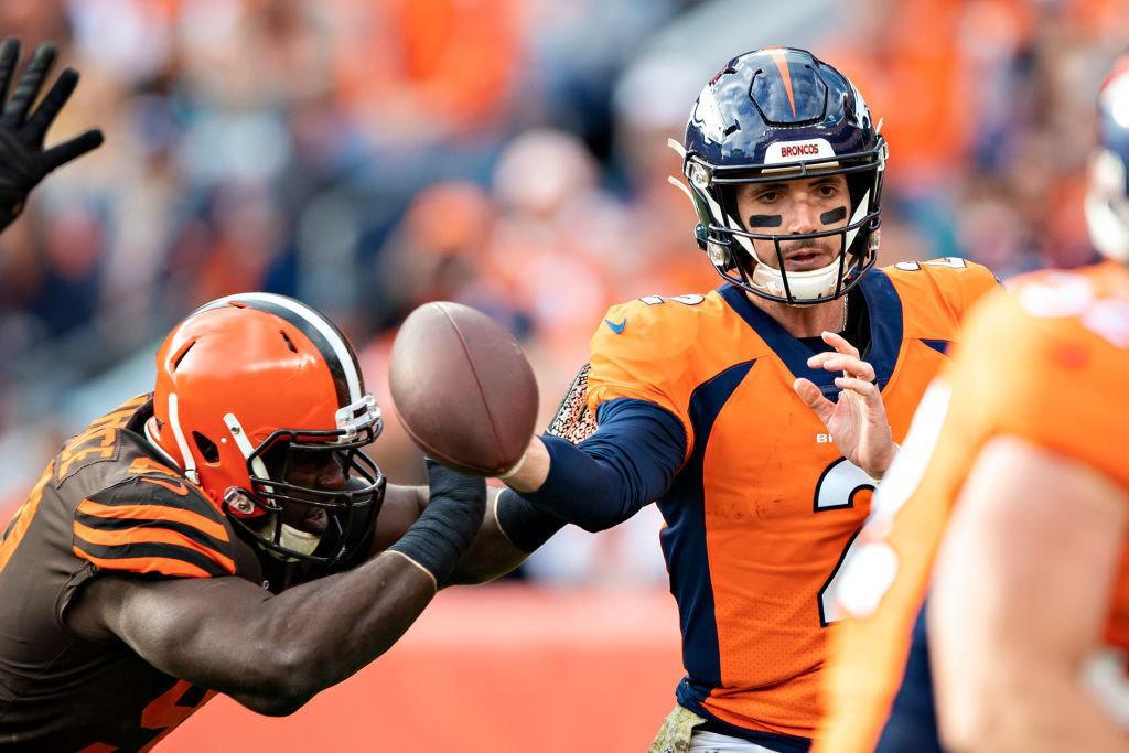 DENVER, CO — NOVEMBER 3: Brandon Allen #2 of the Denver Broncos throws a pass while being hit by Devaroe Lawrence #99 of the Cleveland Browns at Broncos Stadium at Mile High on Nov. 3, 2019 in Denver, Colorado.