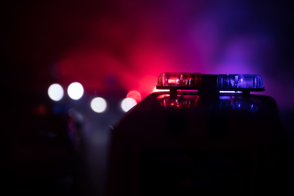 Police car chasing a car at night with fog background. 911 Emergency response police car speeding to scene of crime. Selective focus