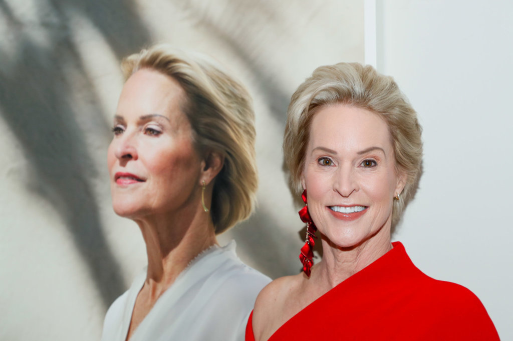 Scientist and Nobel Laureate Frances Arnold poses in front of her image at the gallery gala.