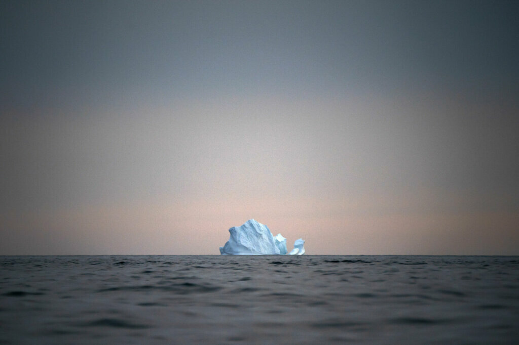 A large iceberg floats away as the sun sets near Kulusuk, Greenland, on Aug. 15, 2019.