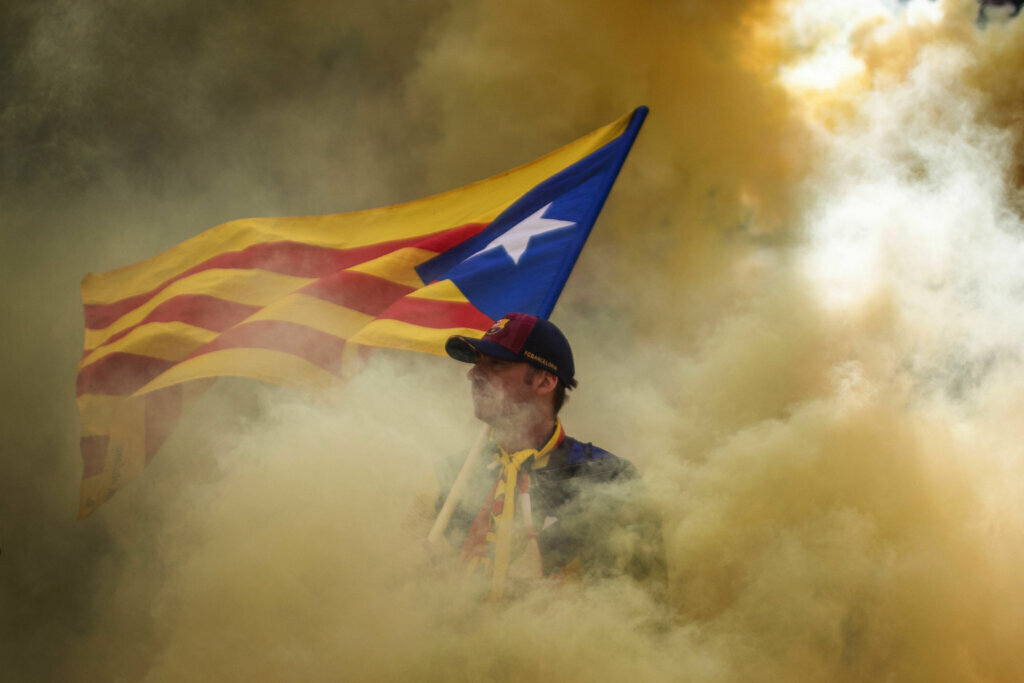 A man holding an independence flag is surrounded by smoke released by demonstrators during the Catalan National Day in Barcelona, Spain, on Sept. 11, 2019. September 11, called "Diada", marks the fall of the Catalan capital to Spanish forces in 1714.