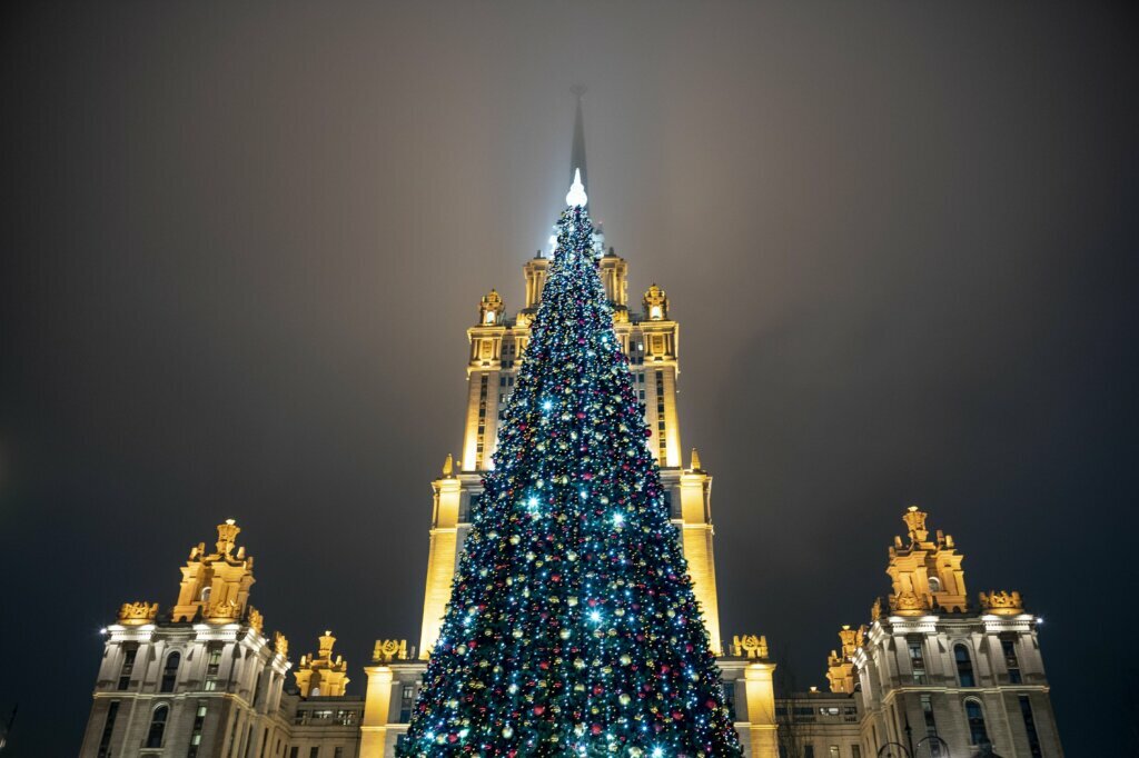 A Christmas tree decorated for Christmas and New Year celebrations placed in front of Stalin's style Ukraine skyscraper, now Radisson Hotel in Moscow, Russia, Tuesday, Dec. 24, 2019.