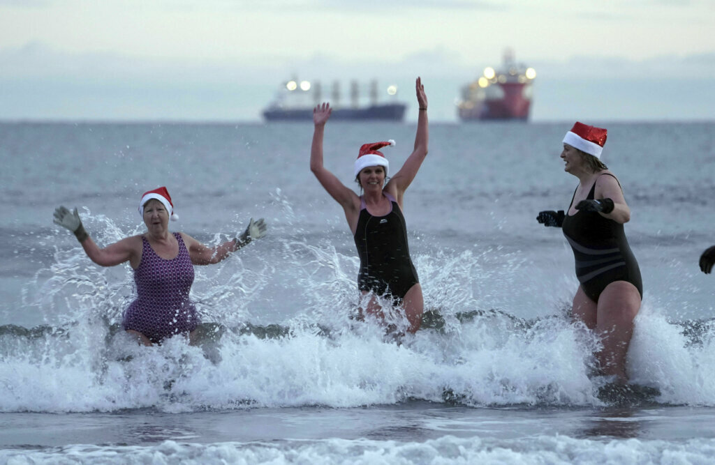 Members of the King Edward's Bay swimmers enjoy a Christmas Day dip at sunrise, at King Edward's Bay, Newcastle, England, Wednesday Dec. 25, 2019.