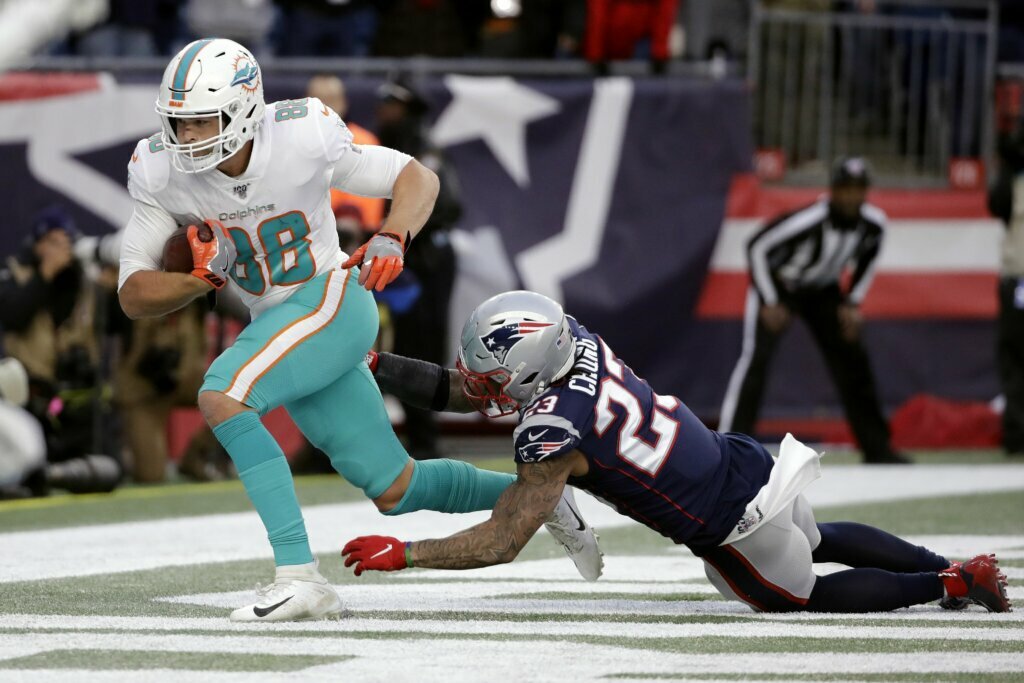 Miami Dolphins tight end Mike Gesicki, left, catches the winning touchdown pass in front of New England Patriots safety Patrick Chung in the second half of an NFL football game, Sunday, Dec. 29, 2019, in Foxborough, Mass.