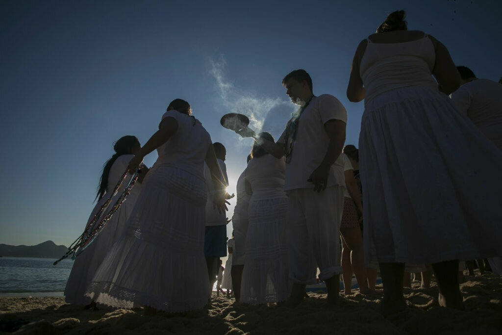 People gather on Praia Vermelha beach to make offerings to Yemanja, a deity from the Yoruba religion, as they honor the African goddess of the sea as part of New Year celebrations in Rio de Janeiro, Brazil, Tuesday, Dec. 31, 2019. As the year winds down, Brazilian worshippers of Yemanja celebrate the deity and ask for blessings for the coming year.