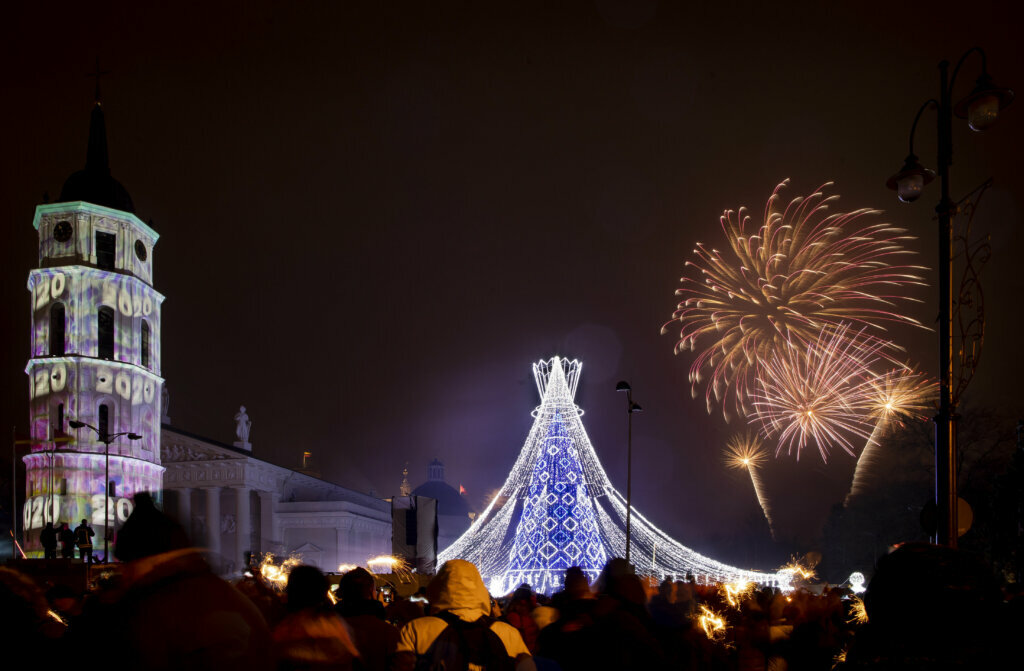 Fireworks light the sky above illuminated Christmas tree at the Cathedral Square in Vilnius, Lithuania, shortly after midnight during the New Year's celebrations, Wednesday, Jan. 1, 2020. Thousands of people celebrated the beginning of the New Year 2020 in the Lithuanian capital.