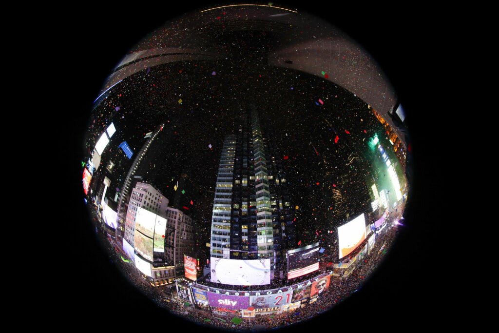In an image taken with a fisheye lens, confetti drops over the crowd as the clock strikes midnight during the New Year's celebration as seen from the New York Marriott Marquis in New York's Times Square, Wednesday, Jan. 1, 2020. (AP Photo/Frank Franklin II)