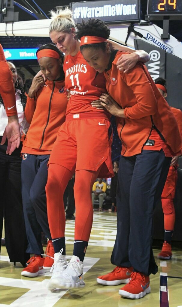 Washington Mystics guard Elena Delle Donne (11) is helped up by fellow players and taken out of Game 2 of a WNBA semifinals basketball playoff after going down against the Atlanta Dream during the second half, Tuesday, Aug. 28, 2018, in Atlanta. The Dream won 78-75.