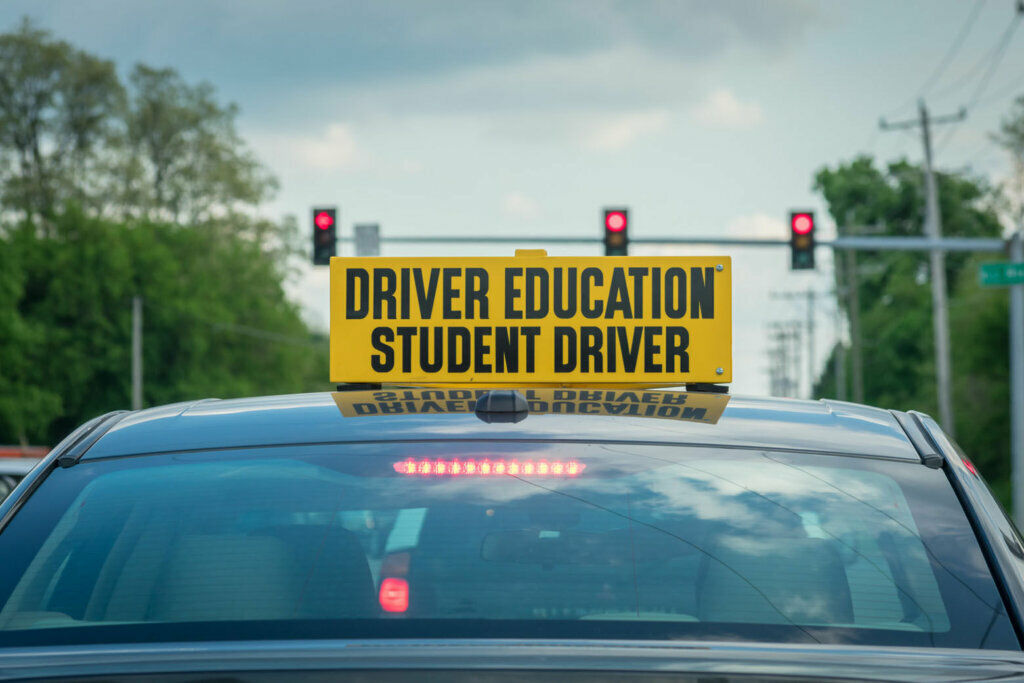 Student driver sign on top of car at stoplight