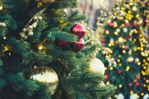 Decorated Christmas tree with red balls and garland. Outdoor fair. Xmas card and pattern. Close up. Winter.