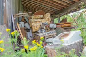 Trash area with vintage materials under old shed in rural Minnesota