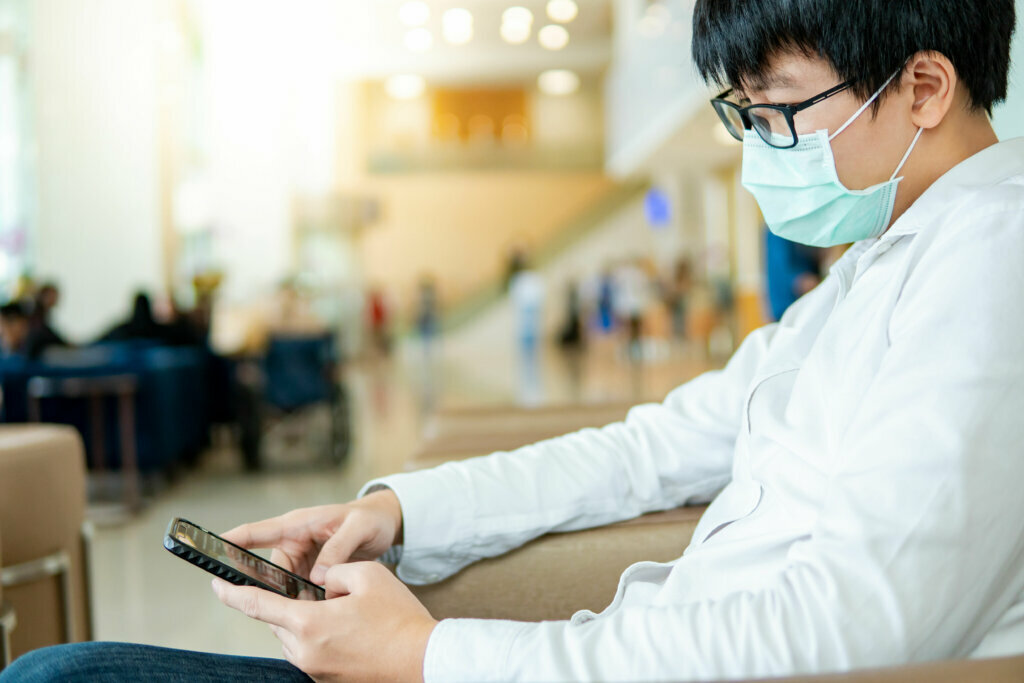 Male patient using smartphone in hospital