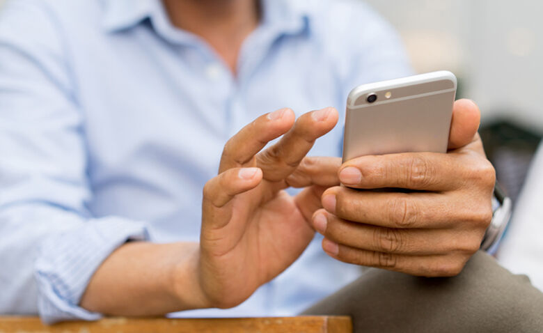 Close up mature businessman holding smartphone and checking news from company by texting to employee , business and technology concept