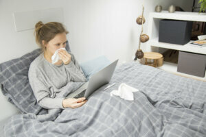 Sad sick girl watching movie in bedroom