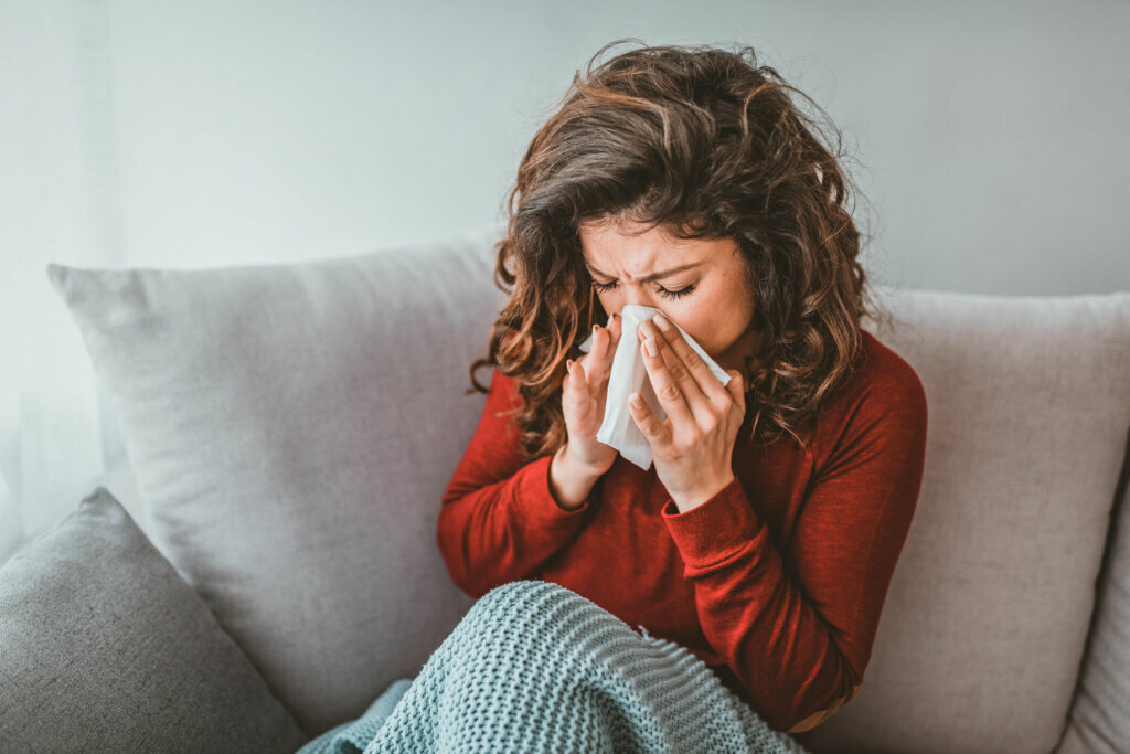 Portrait of woman with allergy blowing her nose