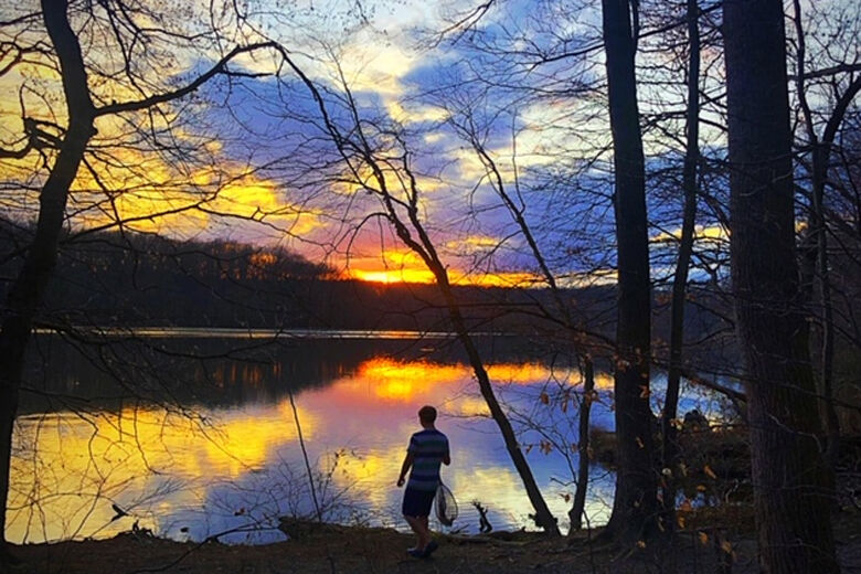 This person enjoys a sunset reflecting off Lake Accotink in Springfield, Virginia.