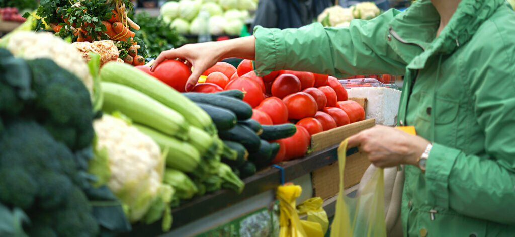 Sales of fresh and organic fruits and vegetables at the green market or farmers market. Citizens buyers choose and buy products for healthy food