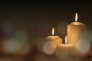 Christmas advent candle light in church with blurry golden bokeh for religious ritual or spiritual zen meditation, peaceful mind and soul, or funeral ceremony