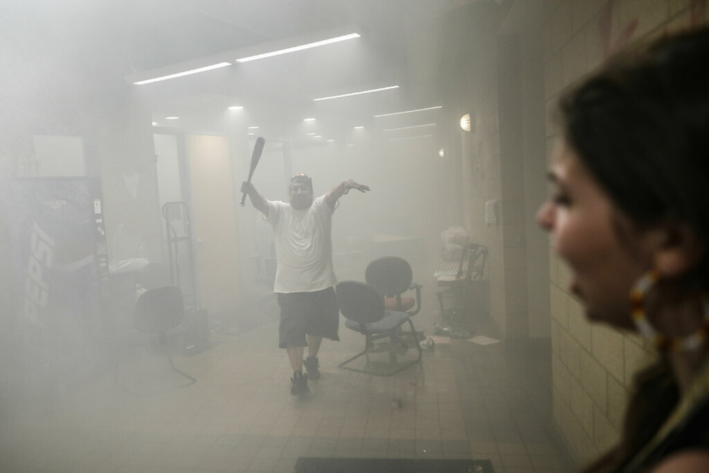 Protesters enter a burning Minneapolis 3rd Police Precinct, Thursday, May 28, 2020, in Minneapolis. Protests over the death of George Floyd, a black man who died in police custody Monday, broke out in Minneapolis for a third straight night. (AP Photo/John Minchillo)