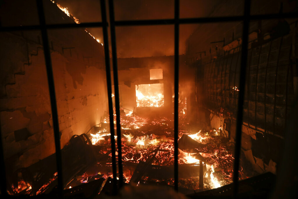 A liquor store is burned during protests near the Minneapolis 3rd Police Precinct, Thursday, May 28, 2020, in Minneapolis. Protests over the death of George Floyd, a black man who died in police custody Monday, broke out in Minneapolis for a third straight night. (AP Photo/John Minchillo)